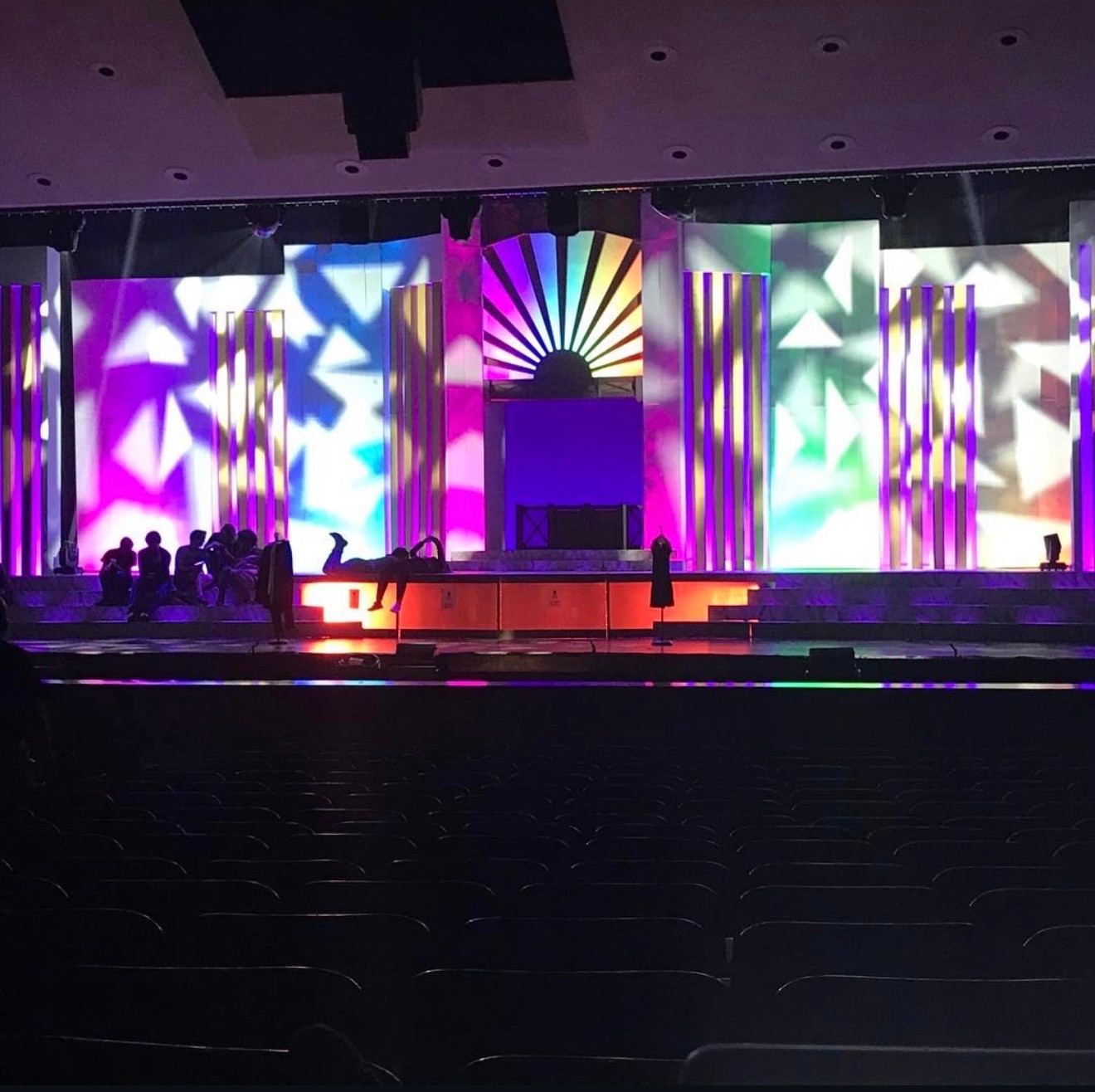 Woman in white dress and bucket hat walking down runway